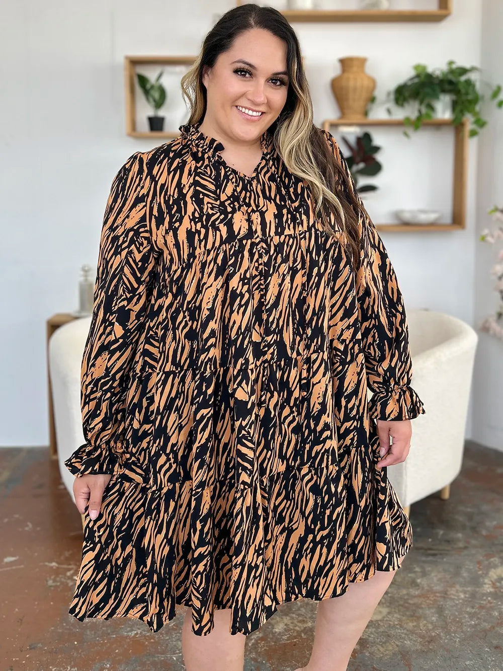 Caramel mini dress worn on a model, showing the tiered ruffle hem from another angle 2