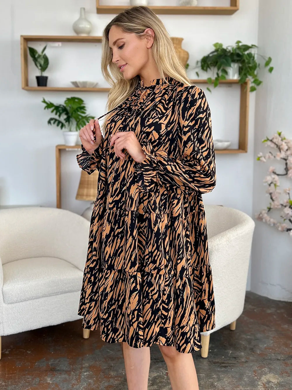 Caramel mini dress worn on a model, showing the tiered ruffle hem from another angle 3
