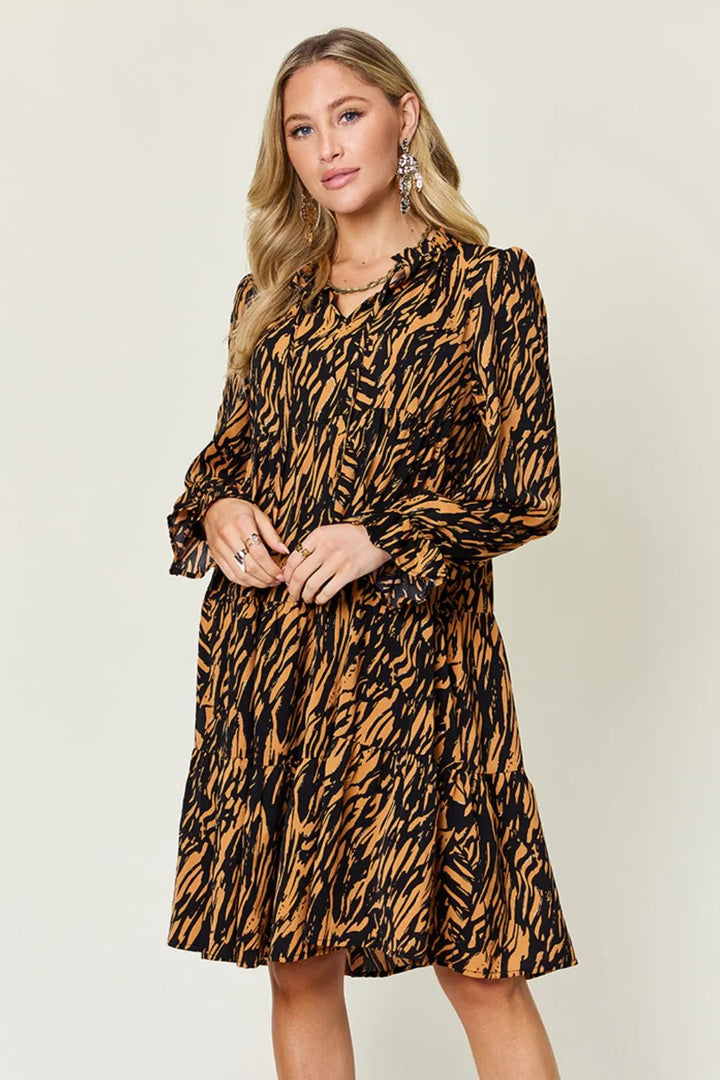 Caramel mini dress worn on a model, showing the tiered ruffle hem