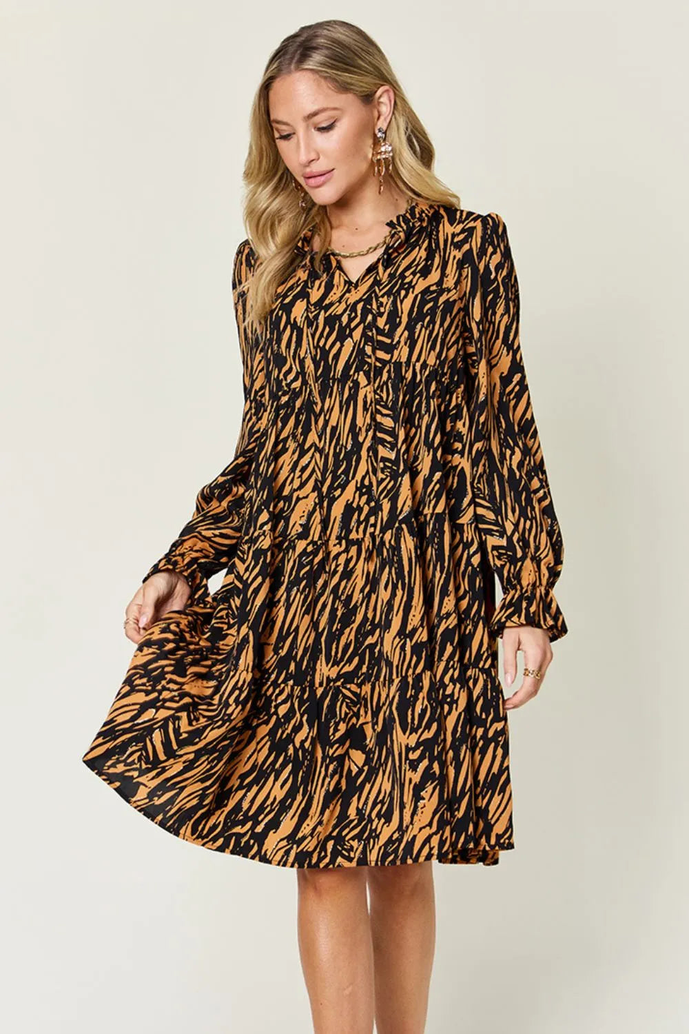 Caramel mini dress worn on a model, showing the all-over animal print