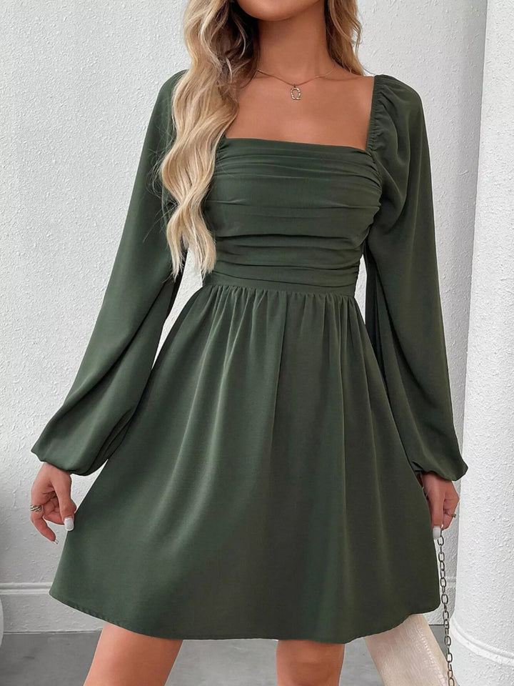 Army green mini dress worn on a model, showing the square neckline
