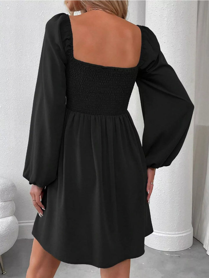 Black mini dress worn on a model, showing the ruched smocked bodice