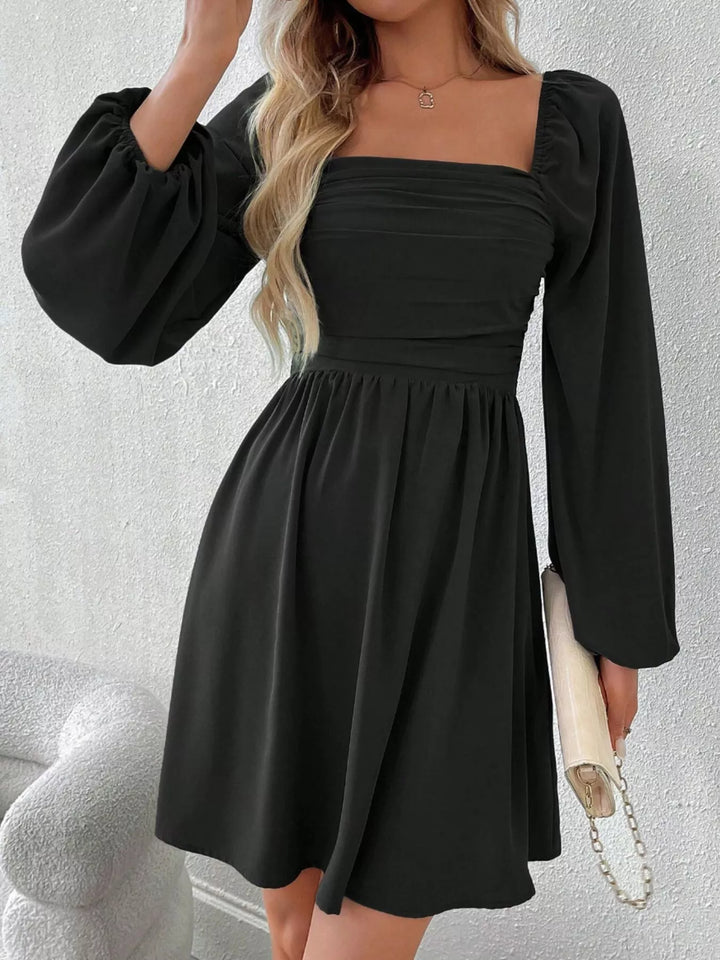 Black mini dress worn on a model, showing the square neckline
