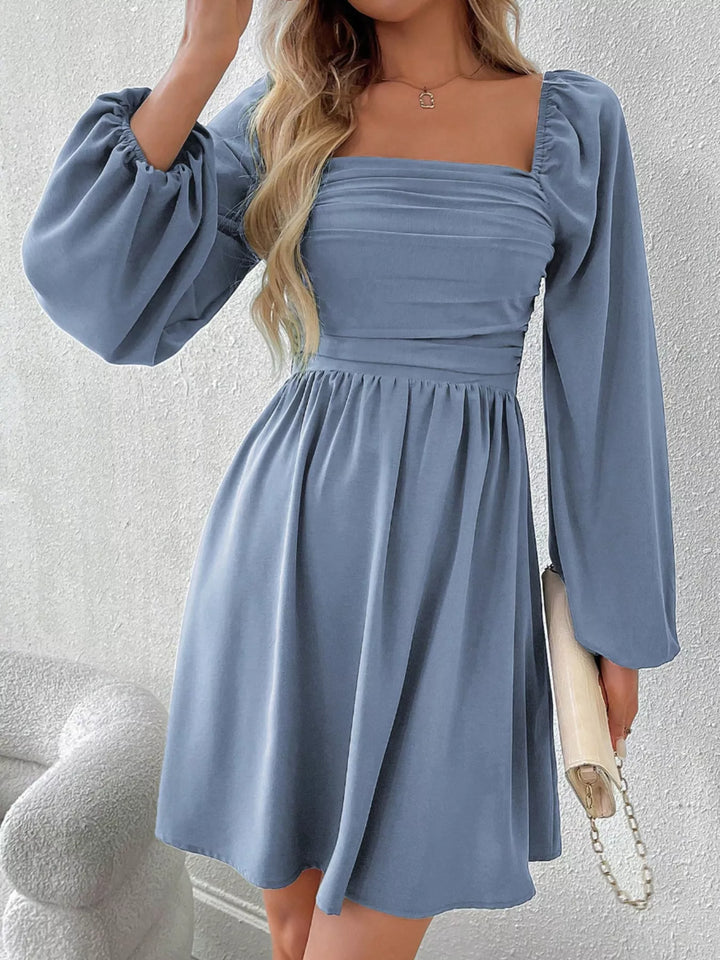 Blue mini dress worn on a model, showing the square neckline