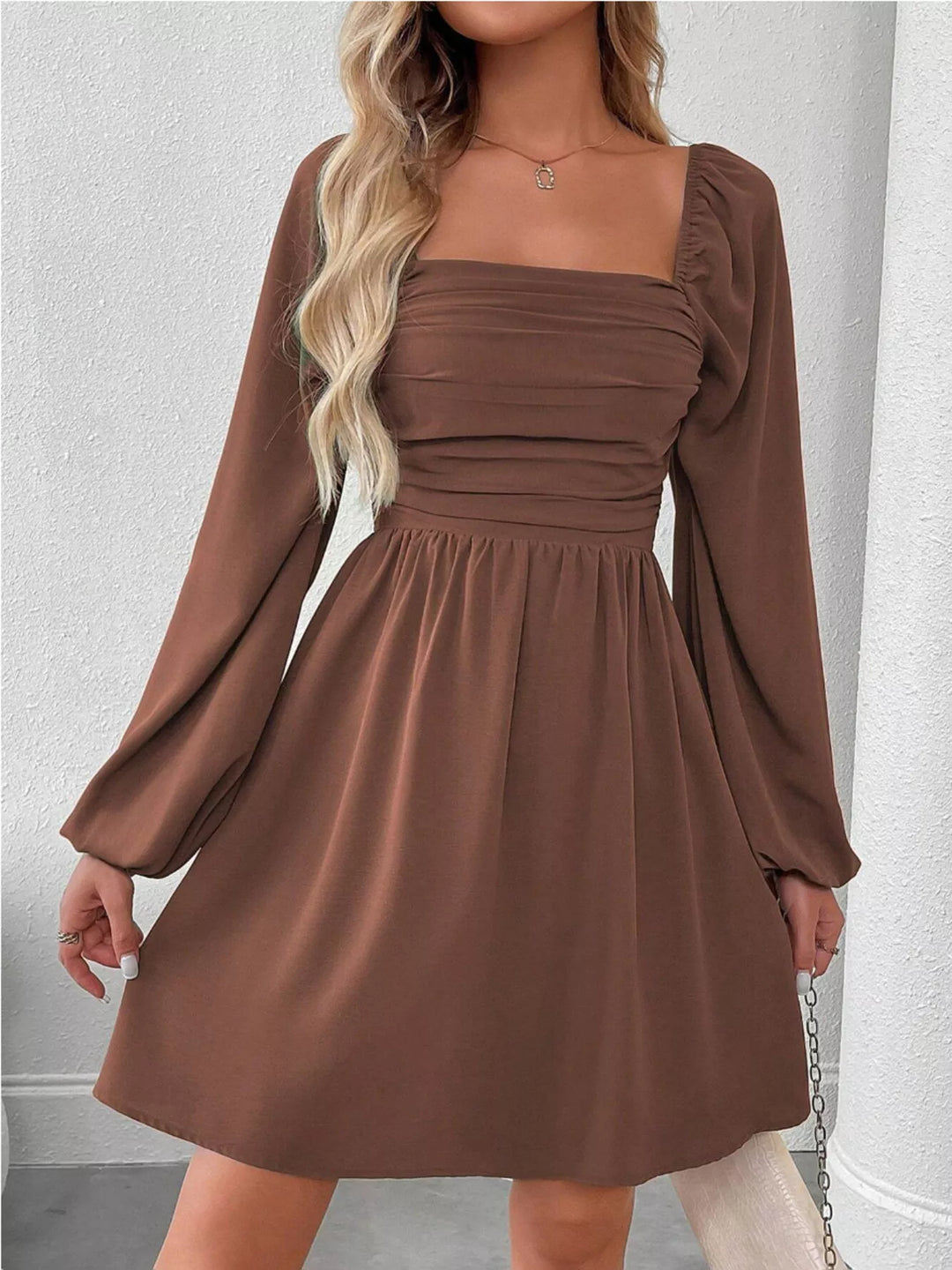 Dark brown mini dress worn on a model, showing the long puff sleeves