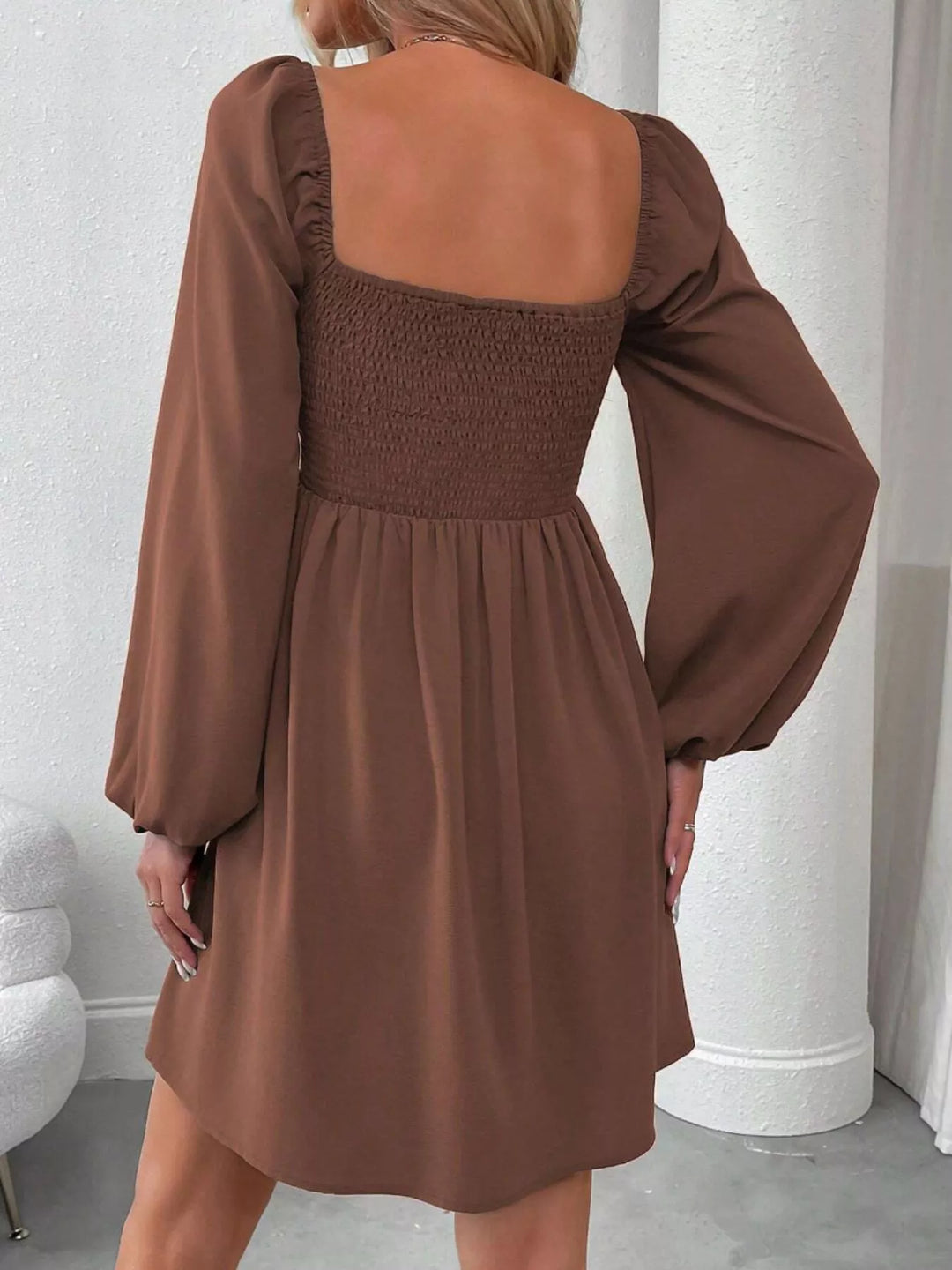 Dark brown mini dress worn on a model, showing the A-line skirt