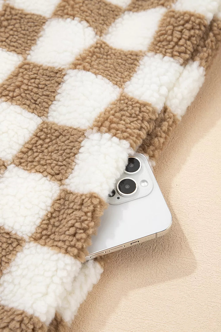 Pocket of the checkerboard jacket holding a phone, showing the plush pattern