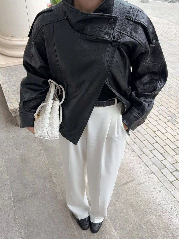 Black funnel collar zip jacket styled with white pants and a clutch