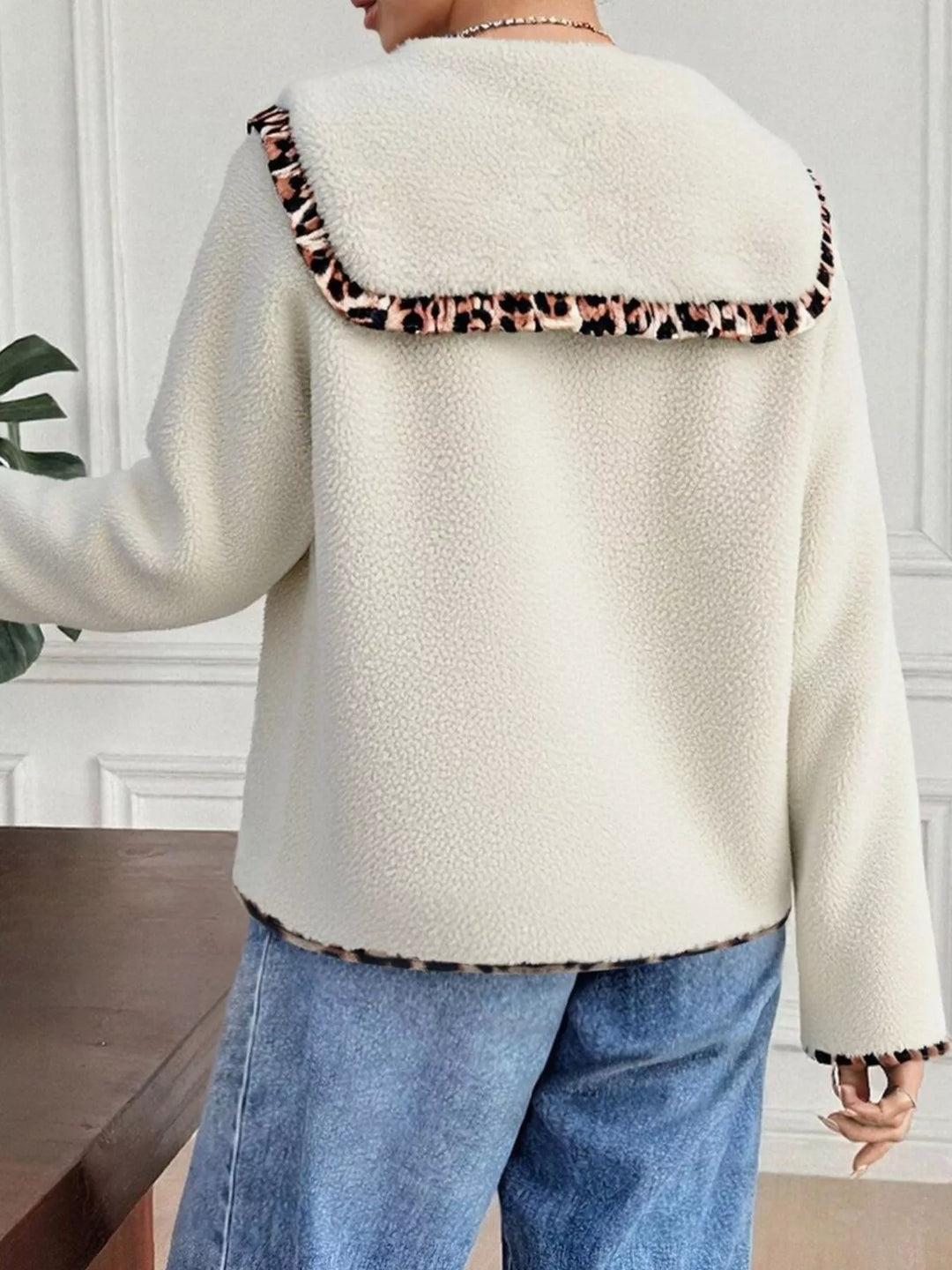Back view of cream plush jacket with leopard trim collar and hem