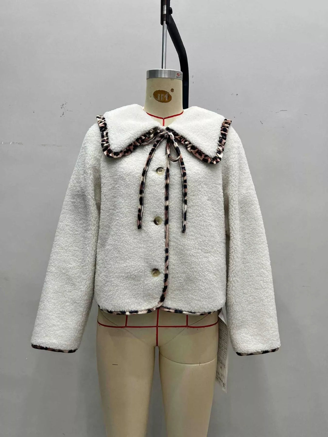 Cream plush jacket with leopard trim front view on a mannequin