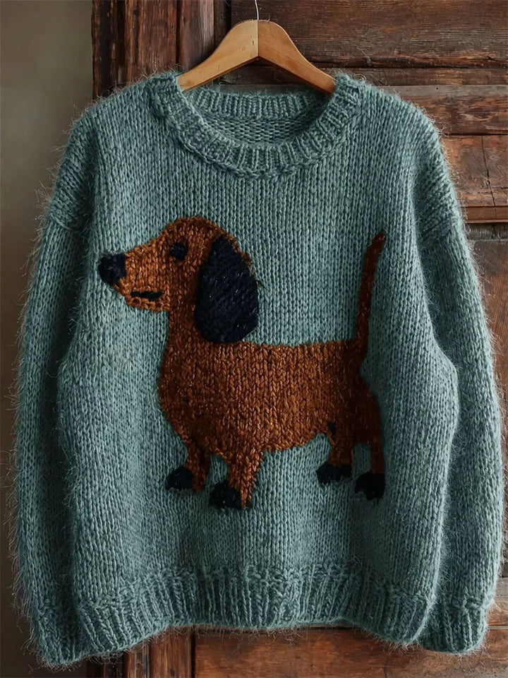 Teal chunky knit dachshund sweater with a crew neck, hanging on a wooden door
