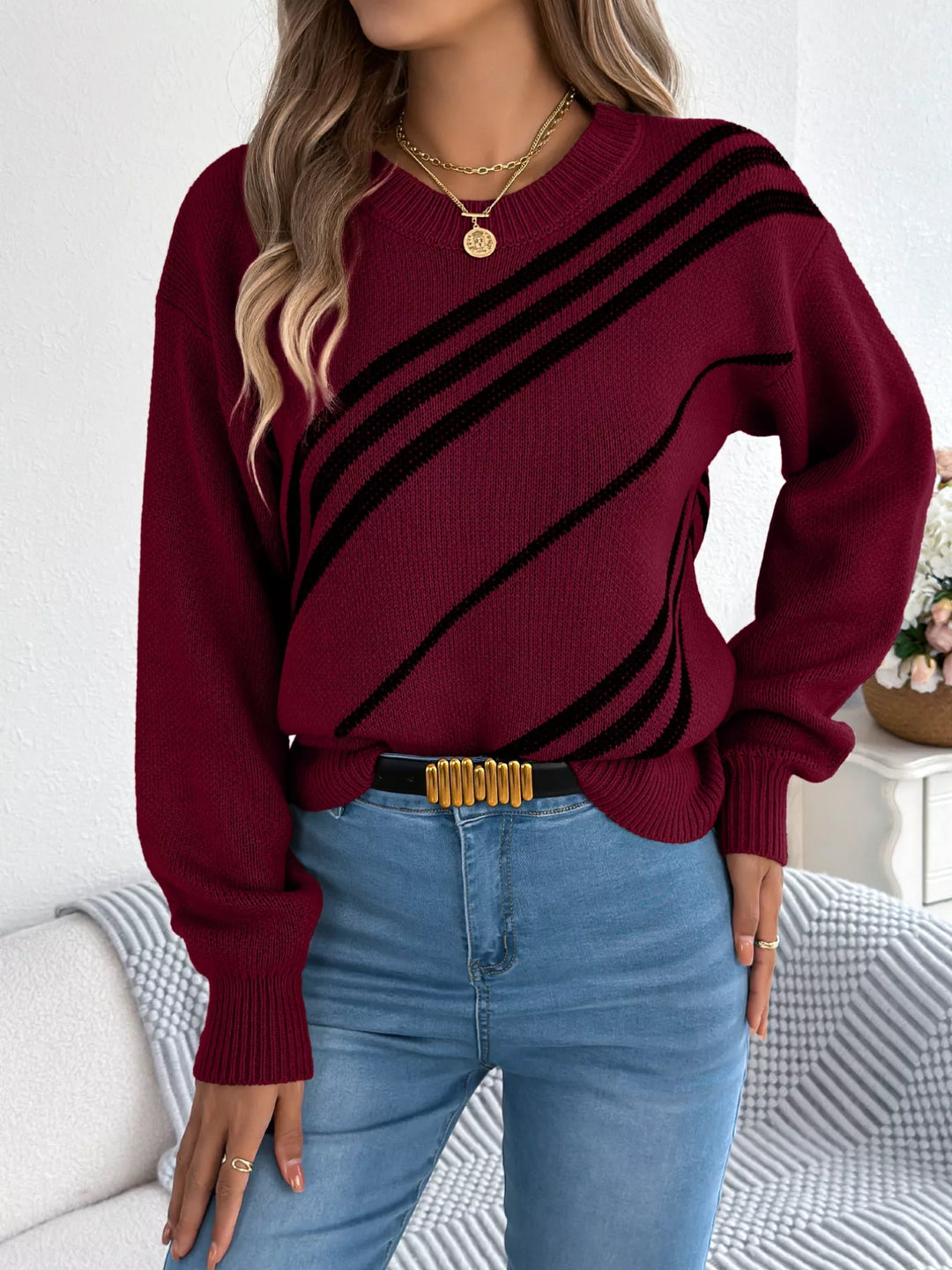 Burgundy diagonal stripe sweater with gold belt buckle and light wash jeans