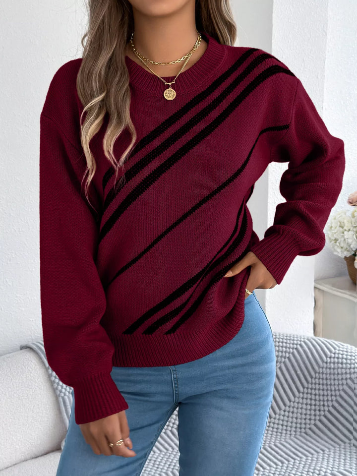 Burgundy diagonal stripe sweater front view with hand on hip and gold necklace