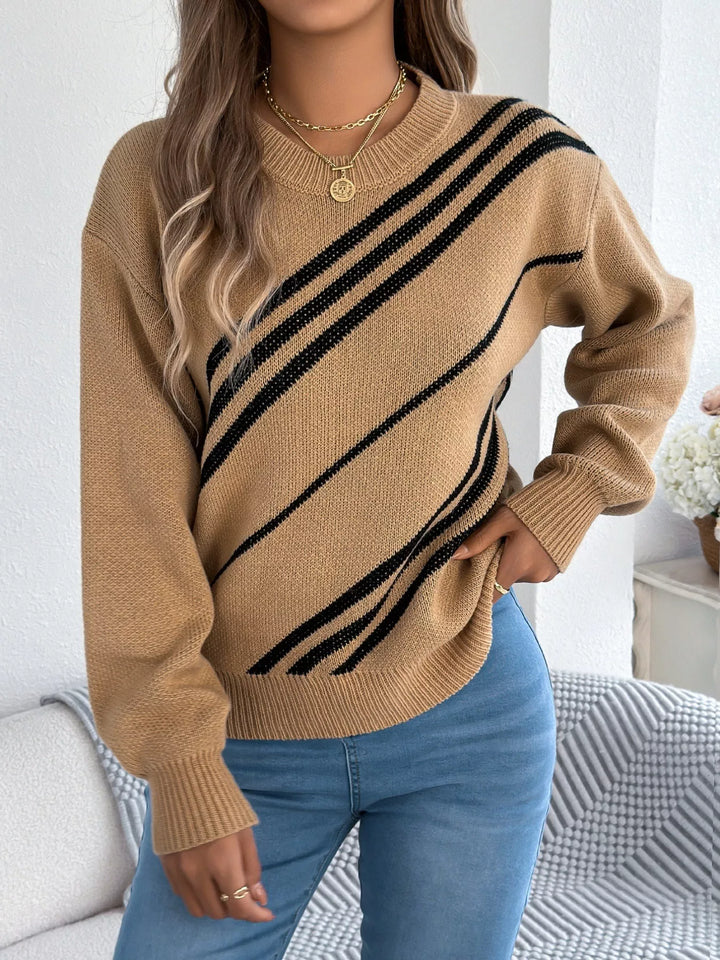 Camel striped sweater three quarter view with hand resting at the hem