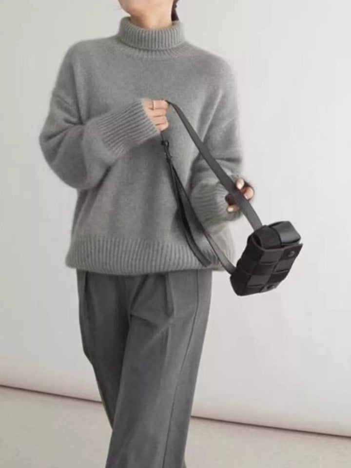 Gray turtleneck sweater styled with a small black crossbody bag