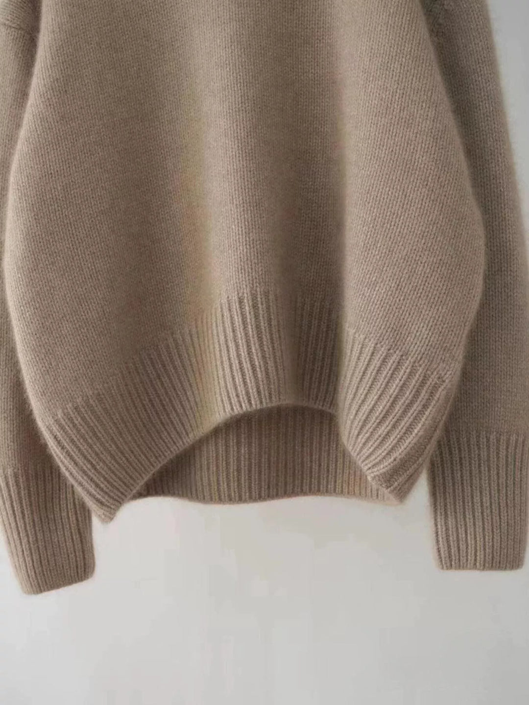 Mocha sweater ribbed hem and sleeve, close-up on a flat surface