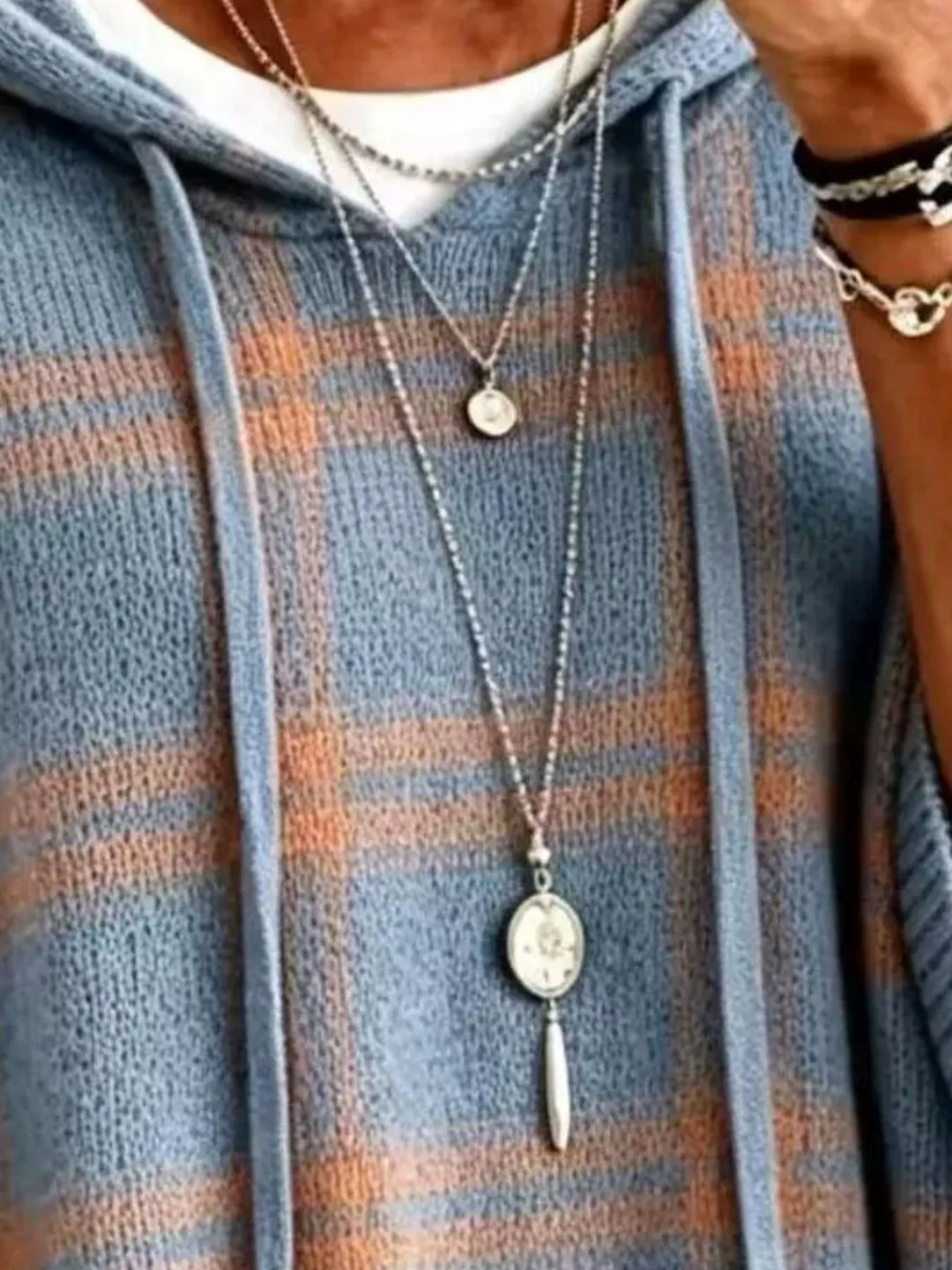 Close-up of the dusty blue plaid hood drawstrings and knit texture
