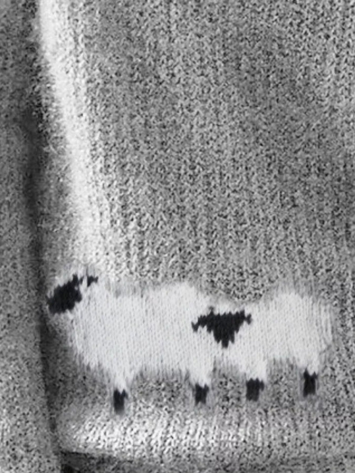 Close-up of the gray knit sweater with a sheep motif at the lower front