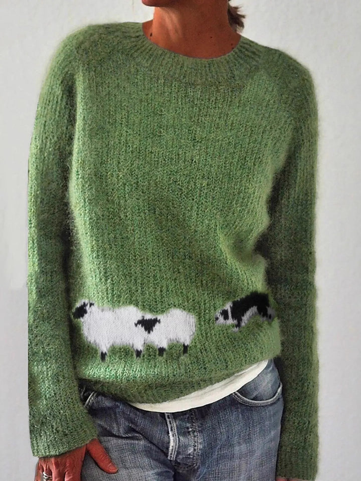 Women's fall sweater in green, sheep motif round neck with raglan sleeves, over jeans