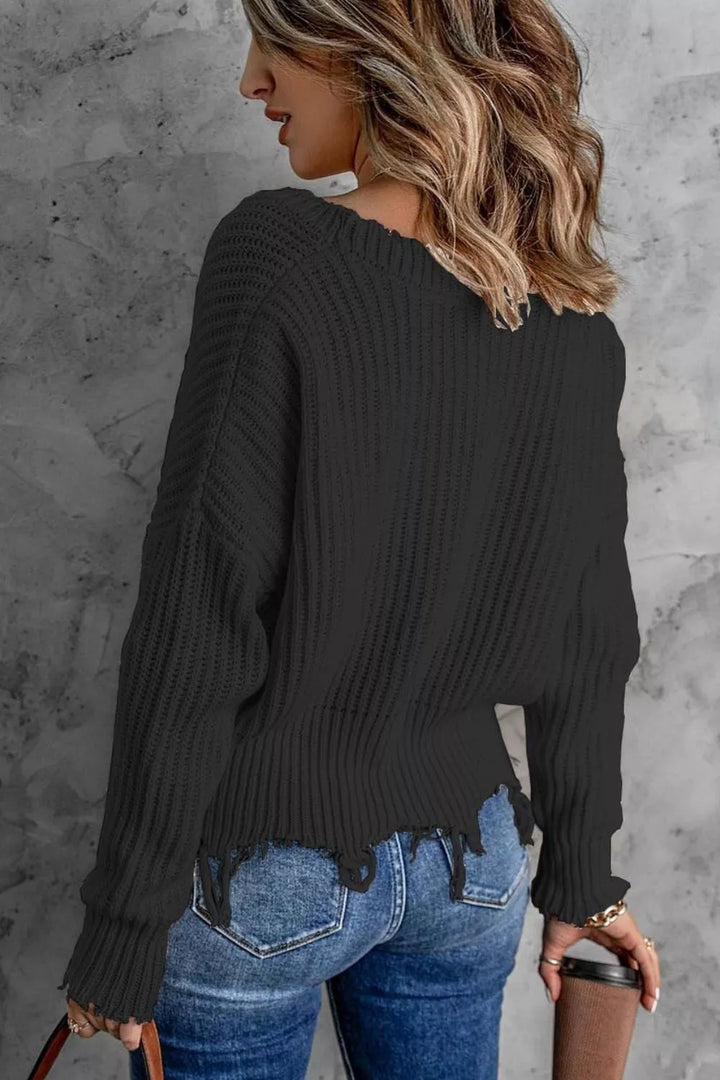 Back angle of the black drop shoulder sweater with frayed bottom edge