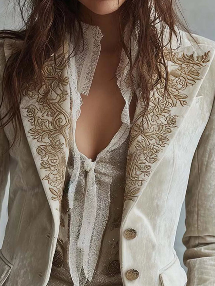 Close-up of the embroidered lapels and buttons on the cream fitted blazer