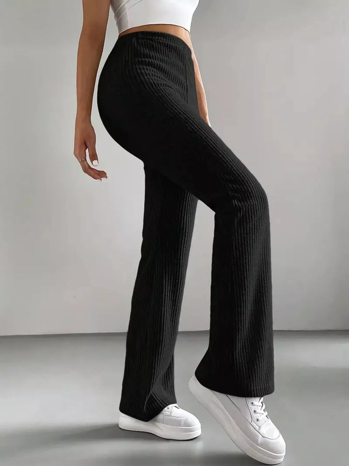 Black stretch flare pants from the side showing fitted thigh and flared hem