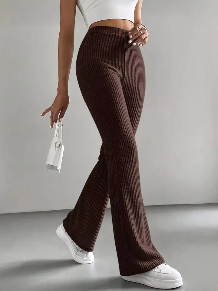 Chocolate brown ribbed flare pants front view with white sneakers