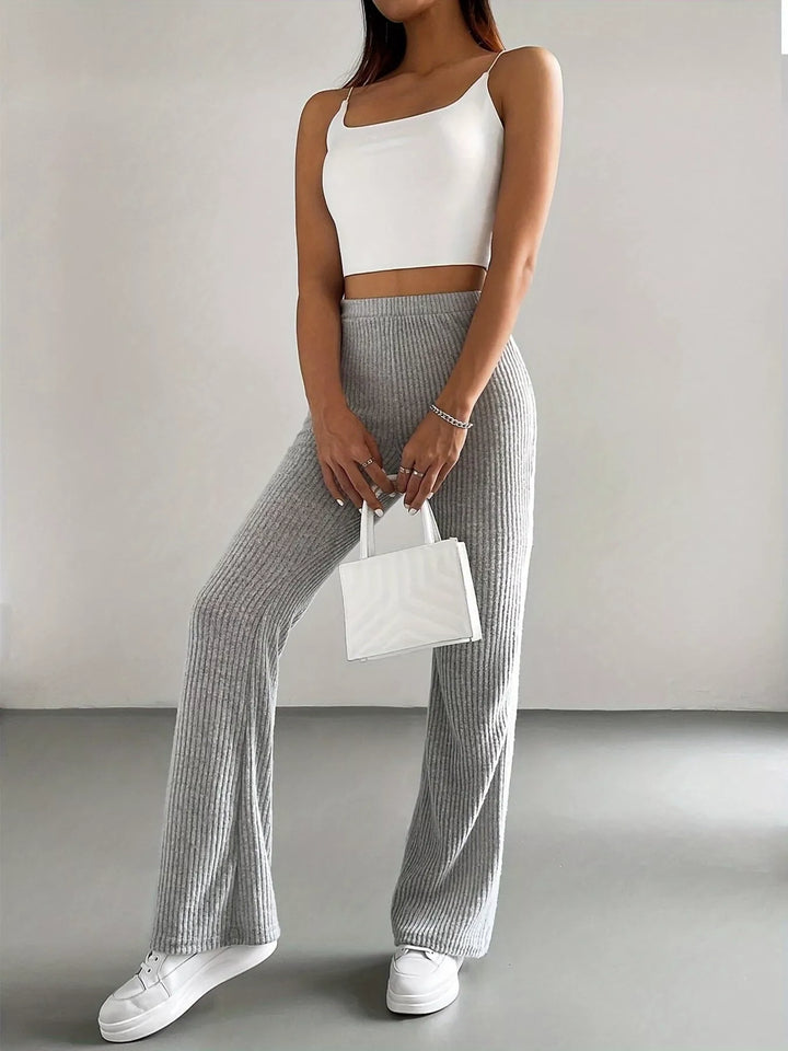 Heather gray flare pants styled with a white cami and small white handbag
