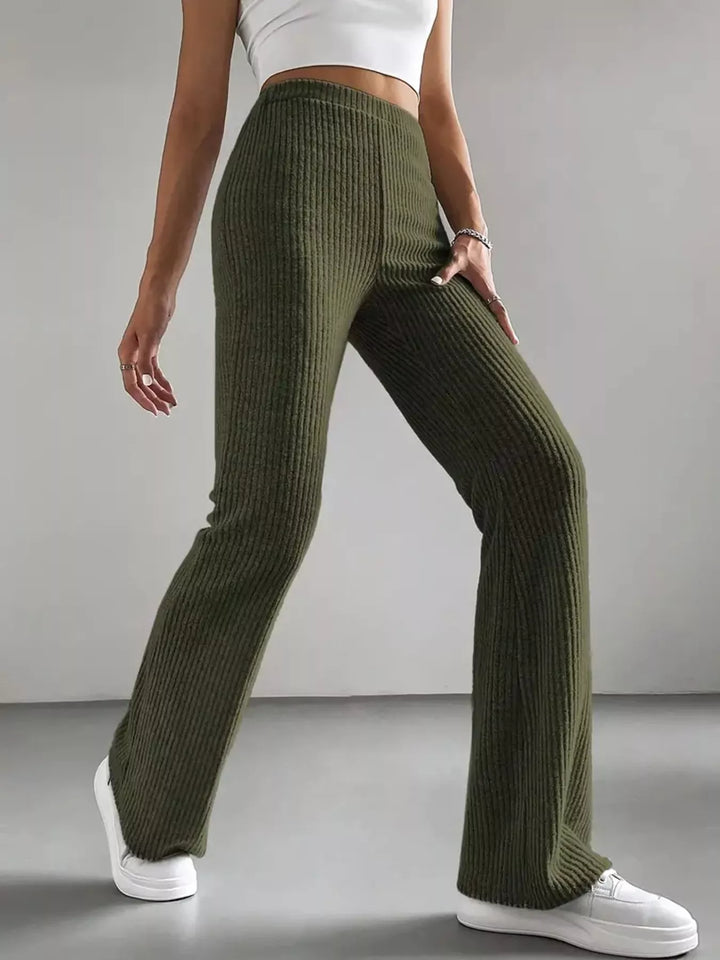 Olive green ribbed flare pants front view with a white handbag