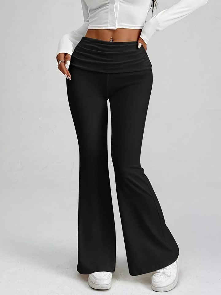 Plain black stretch flare pants with a ruched fold over waistband, front view