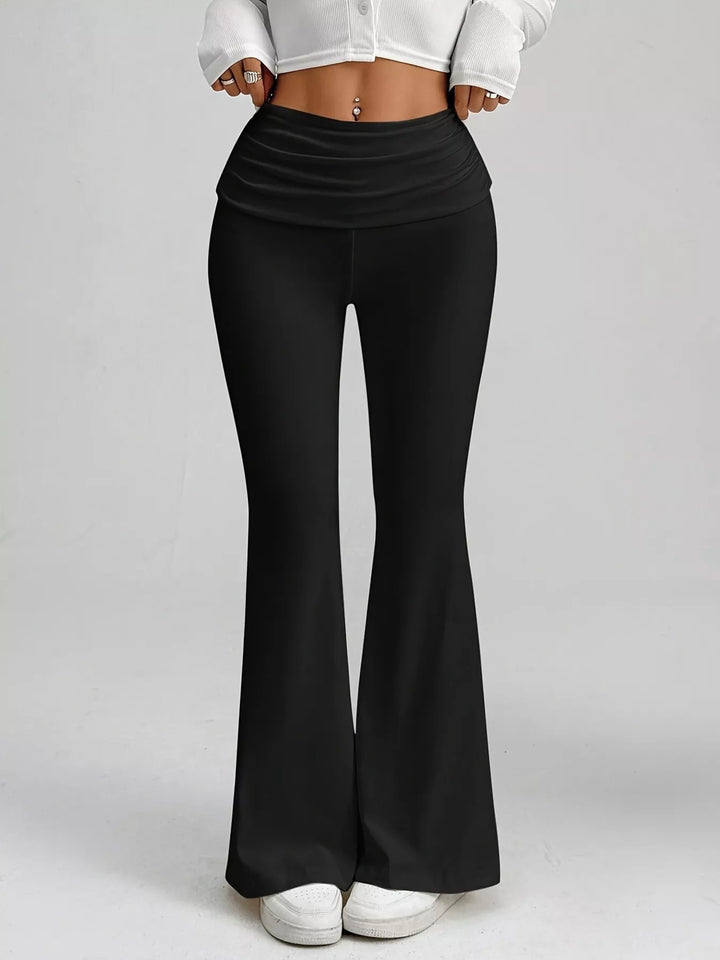 Full-length black flare pants with slim thigh, worn with a white cropped top
