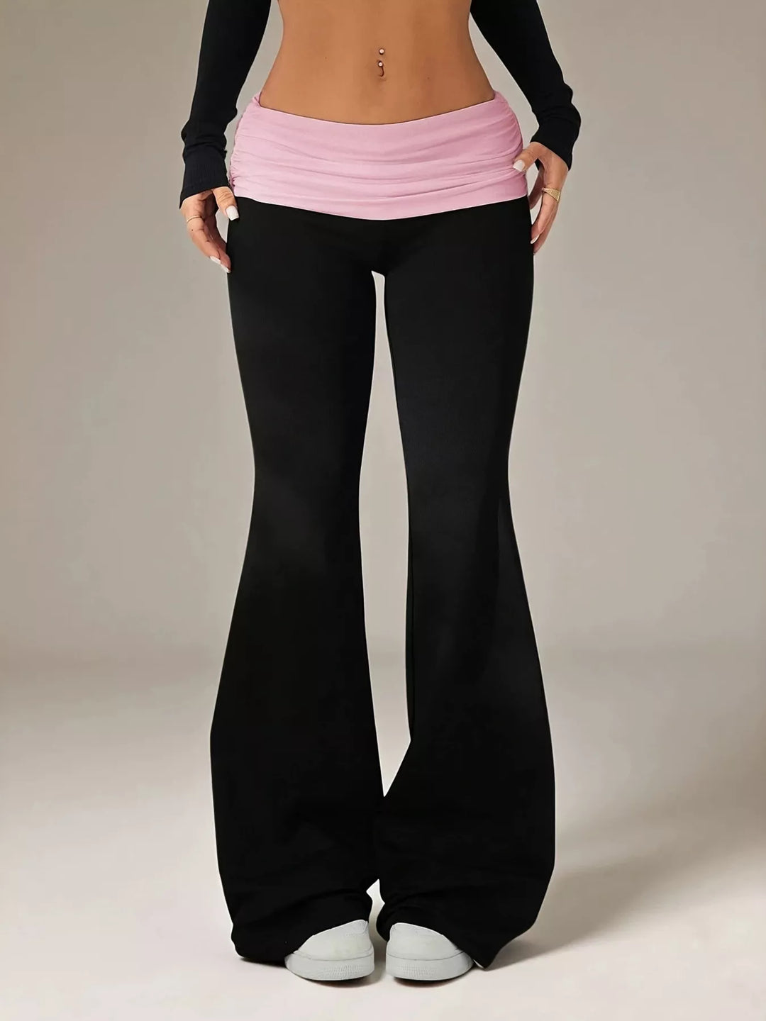 Black flare pants with a pink fold over waistband, front view