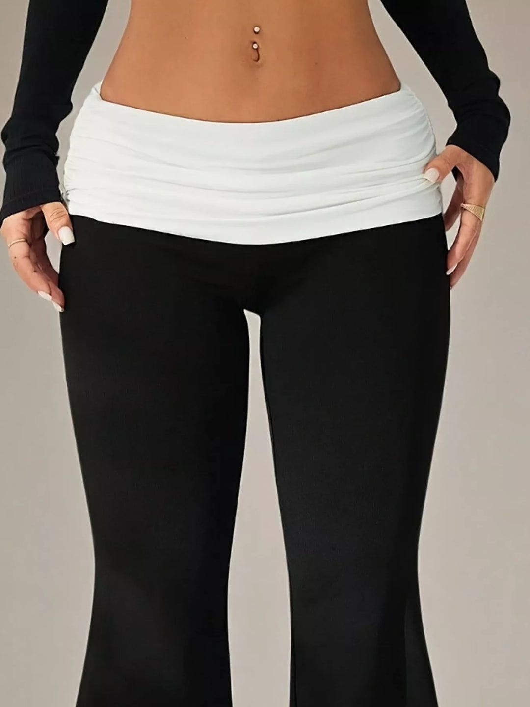 Close-up of the white ruched fold over waistband on the black flare pants