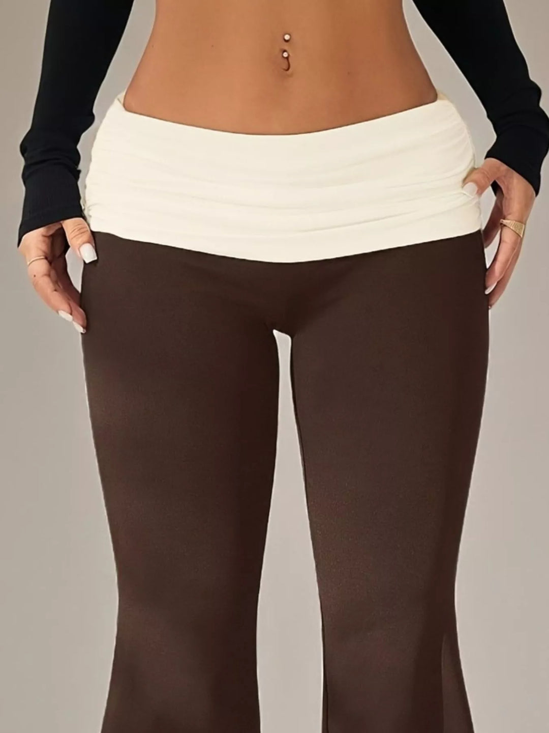 Close-up of the cream ruched waistband on the brown stretch flare pants