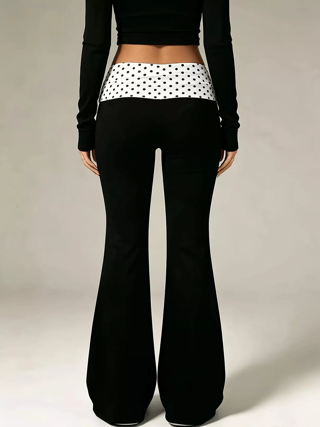 Back view of the black flare pants with a polka dot fold over waistband