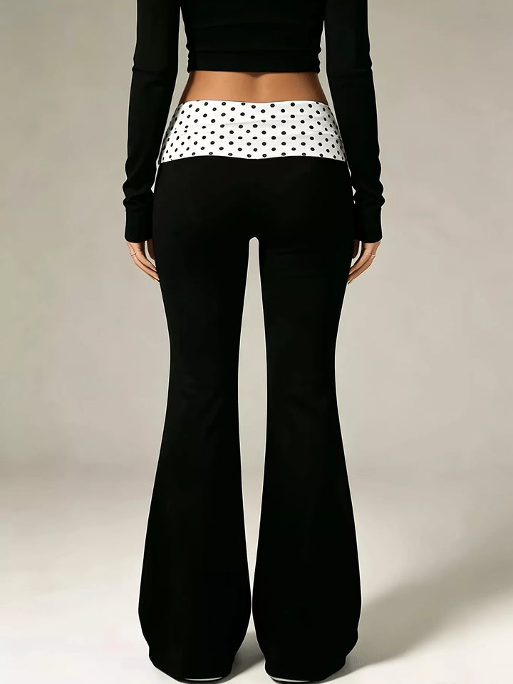 Back view of the black flare pants with a polka dot fold over waistband