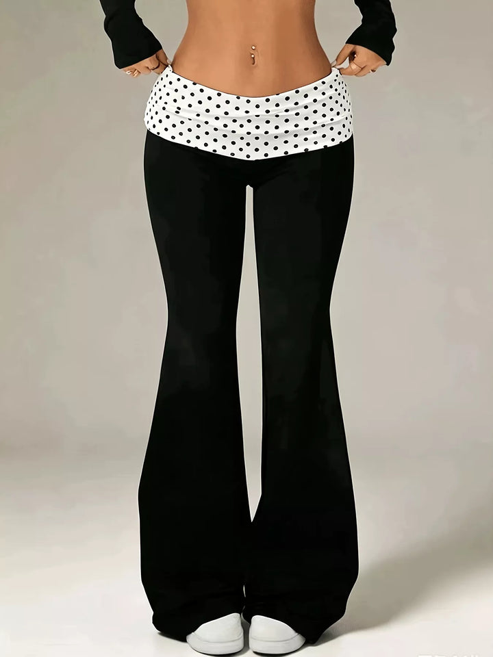 Women's flare pants in black with a polka dot fold over waistband, front view