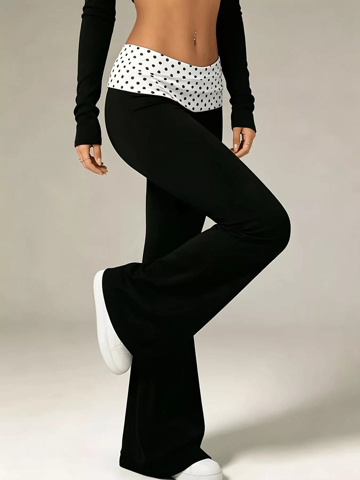 Side pose in the polka dot waistband flare pants with one leg lifted