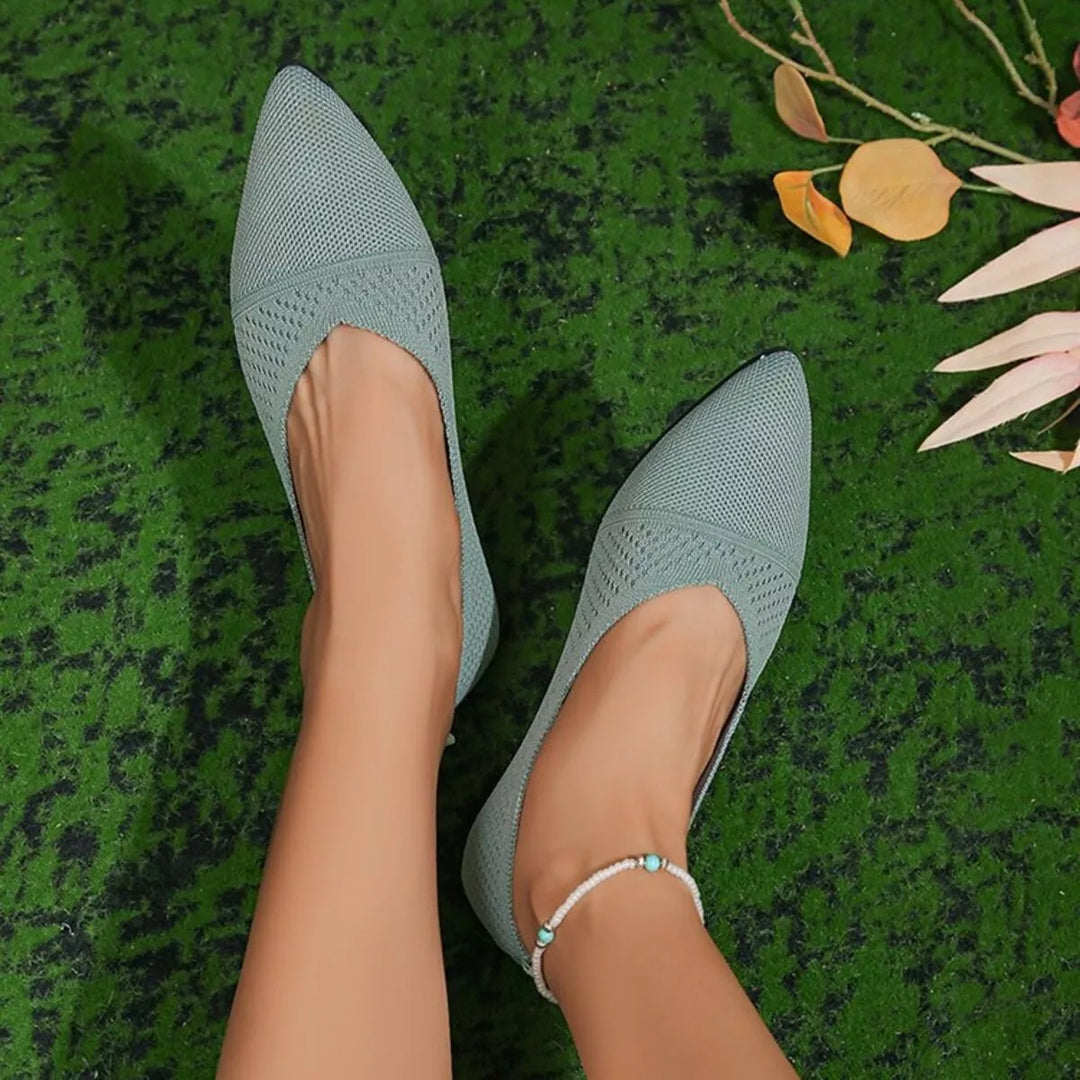 Pair of sage knit slip on flats seen from above on the feet