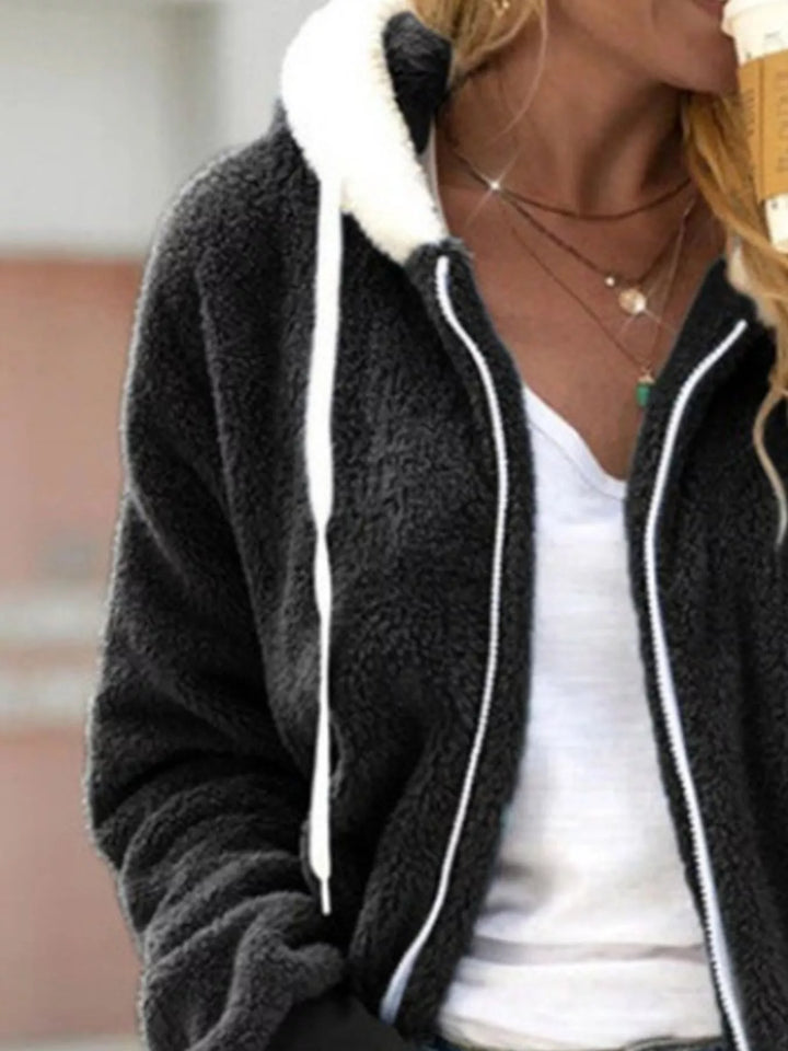 Black hooded fleece jacket close-up with white drawstrings and zipper