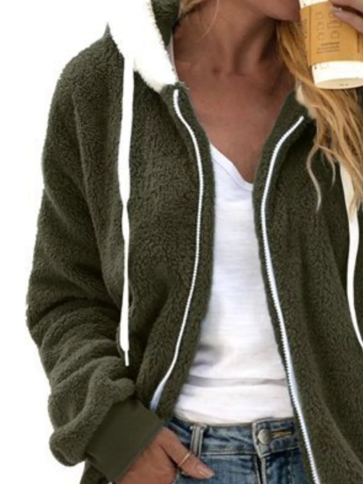 Olive green hooded fleece jacket with white drawstrings, standing pose with jeans