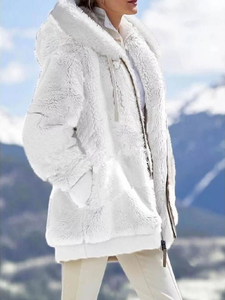 White fuzzy hooded fleece jacket, zip up style with pockets, outdoor mountain backdrop