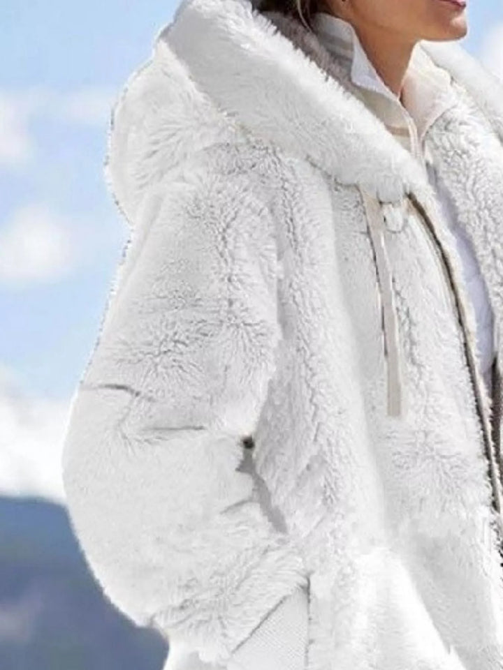 White fleece jacket with hood, side view in a snowy mountain setting
