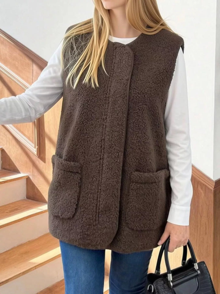 Coffee brown fuzzy vest with round neck and patch pockets, front view with a bag