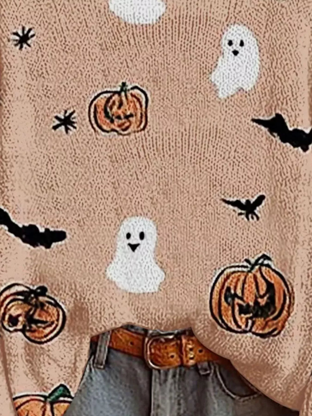 Close-up of blush fuzzy sweater with ghost, pumpkin and bat prints