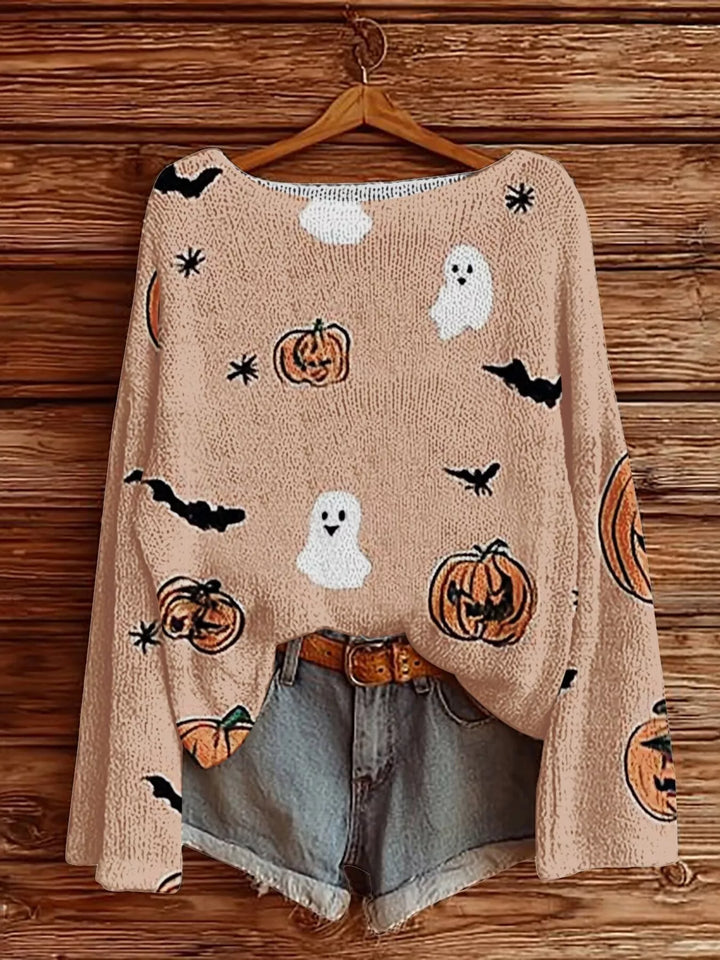 Women's Halloween sweater in blush with ghosts, pumpkins and bats, hanging with denim shorts