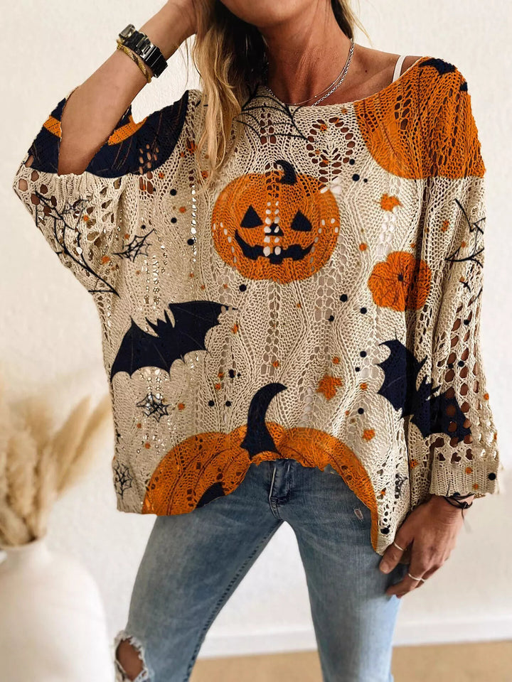 Women's Halloween sweater in beige, oversized pumpkin and bat print, worn with jeans