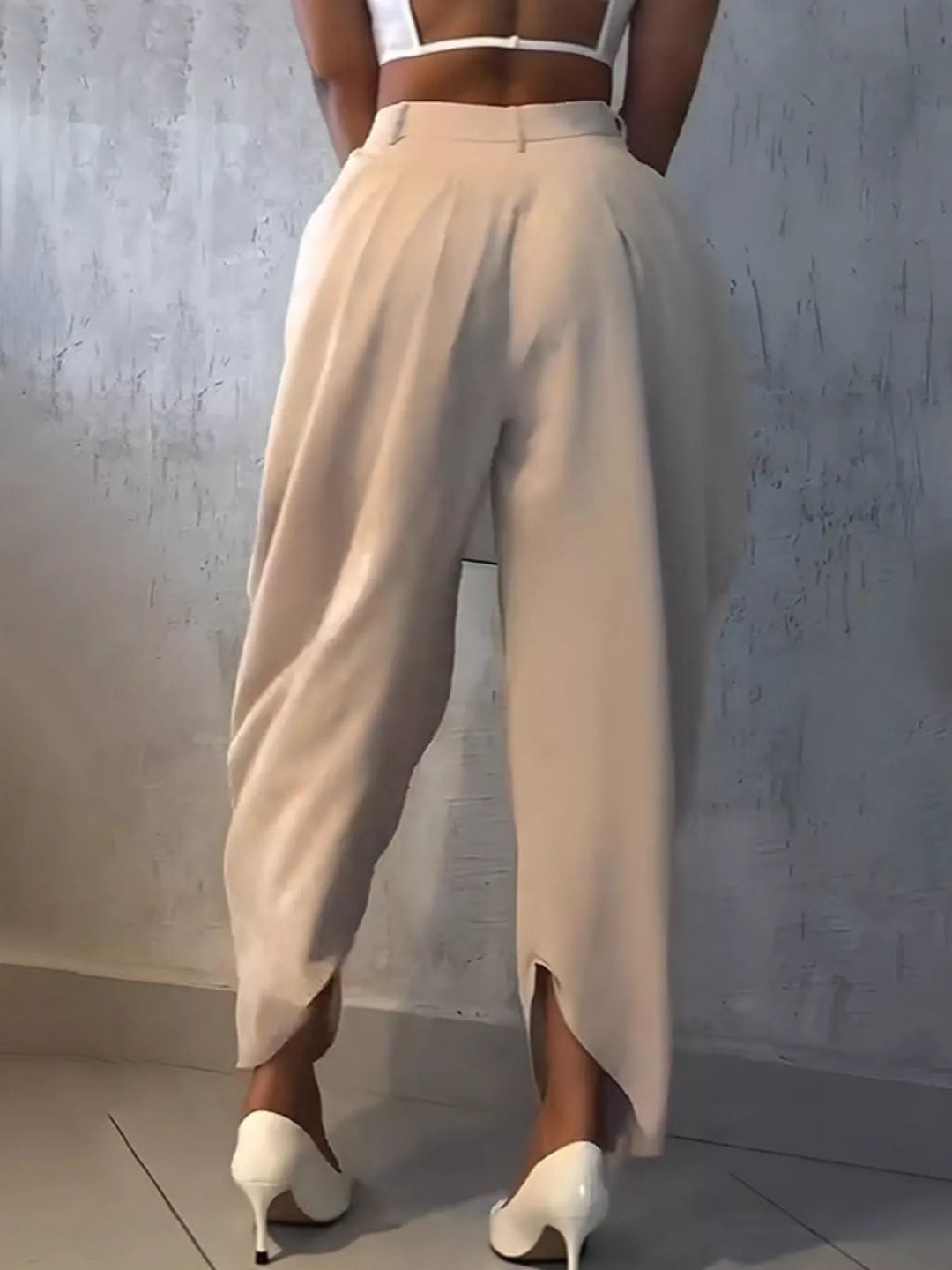 Back view of beige harem pants with the wrapped hem gathered at the ankle