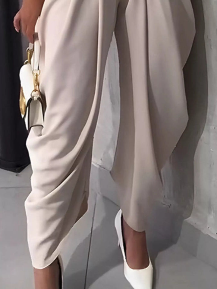 Side view of cream pleated harem pants showing the draped wrapped hem