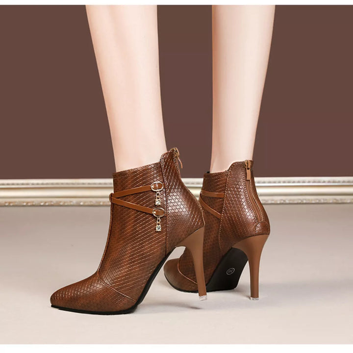 Cognac pointed toe heeled boots pair showing the zipper and gold charm